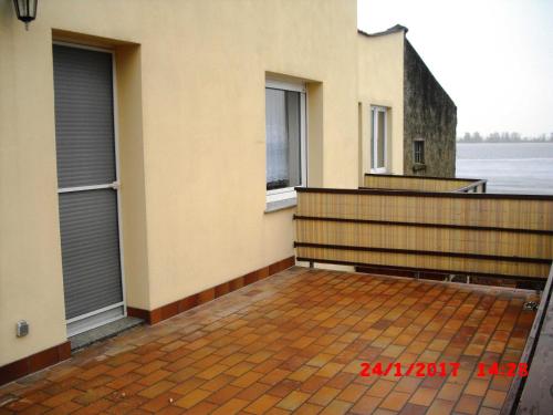 a balcony of a house with two windows at Ferienwohnung am Peenestrom in Kölpin