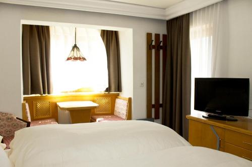 a hotel room with a bed and a flat screen tv at Alpenhotel Tirolerhof in Fulpmes