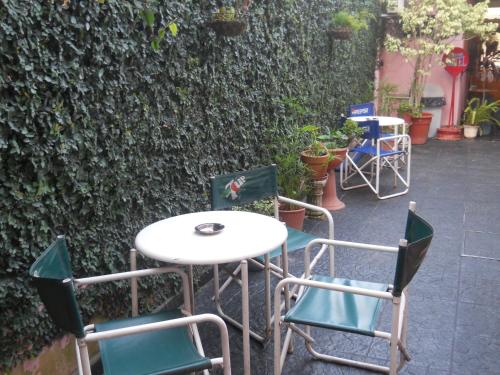 a table and chairs in front of a wall at Dennisse Hotel in Victoria
