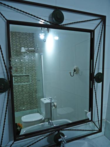 a bathroom with a shower and a toilet and a sink at Pousada Bárbara Heliodora in Tiradentes
