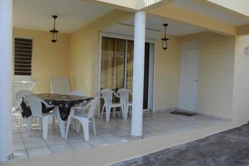 a patio with a table and chairs on a house at Marcus972 in Sainte-Luce