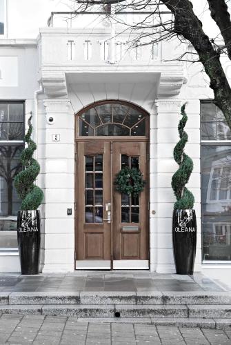 a building with a wooden door with two plants at Hotel Oleana in Bergen
