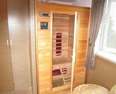 
a room with a wooden door and a wooden shelf at Gau Shan Ching Hotel in Zhongzheng
