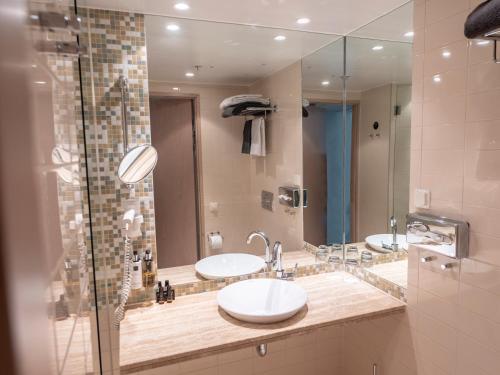 a bathroom with two sinks and a large mirror at Clarion Hotel Sign in Stockholm