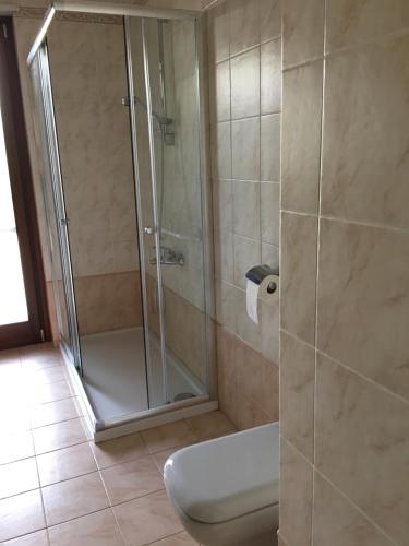 a bathroom with a glass shower with a toilet at La tua casa a Matera in Matera