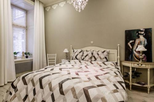 ein Schlafzimmer mit einem großen Bett und einem Kronleuchter in der Unterkunft Main Street in Budapest