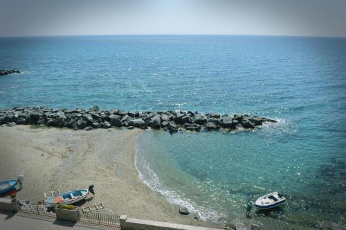 an aerial view of a beach with boats in the water at Hotel La Riva in Giardini Naxos