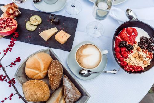 a table with a plate of food and a cup of coffee at Hotel Castel Rundegg (Adults Only) in Merano