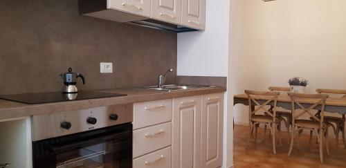 a kitchen with a sink and a table with chairs at Le Casette Di Osvaldo in Lecco