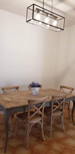 a wooden table with chairs and a vase on it at Le Casette Di Osvaldo in Lecco