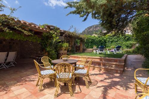 a patio with wicker chairs and a table and chairs at Ca Mado Xucla in Valldemossa