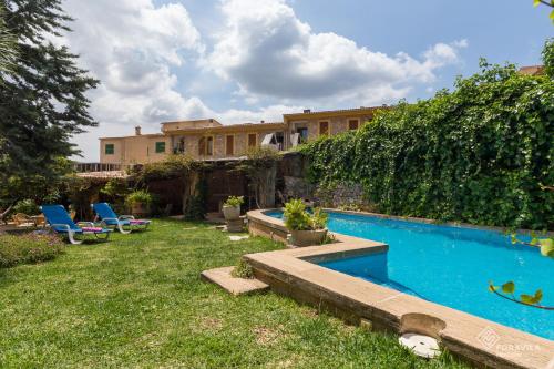 a backyard with a swimming pool and a house at Ca Mado Xucla in Valldemossa