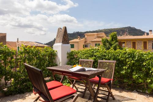 a wooden table and chairs with a book on it at Ca Mado Xucla in Valldemossa