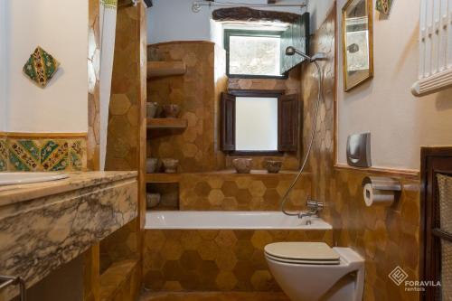 a bathroom with a toilet and a tub and a sink at Ca Mado Xucla in Valldemossa