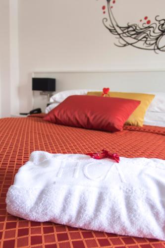 a bed with white towels on it with a red pillow at Hotel Villa Chiara in Terracina