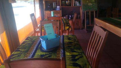 a dining room table with a blue basket on it at Tranquillity Day Spa & Lodge in Baviaanspoort