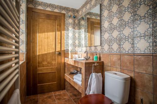 a bathroom with a toilet and a sink and a mirror at La Aldea Colorada in Mota del Marqués