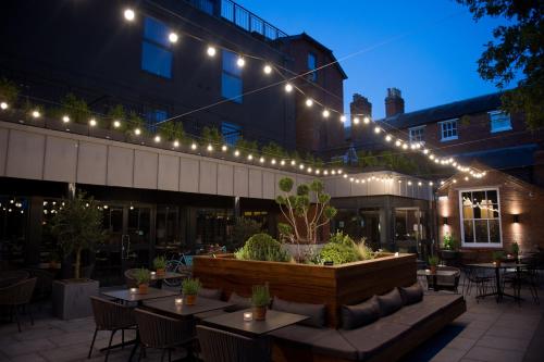 a patio with tables and chairs and lights at Hotel Du Vin Stratford in Stratford-upon-Avon