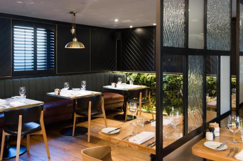 a restaurant with tables and chairs in a room at Hotel Du Vin Stratford in Stratford-upon-Avon
