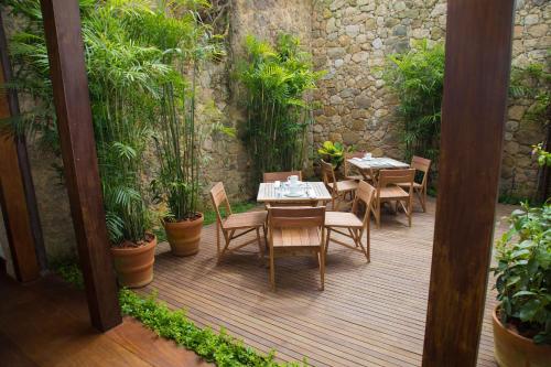 a patio area with a table, chairs, and a patio table at Pousada Literária de Paraty in Paraty