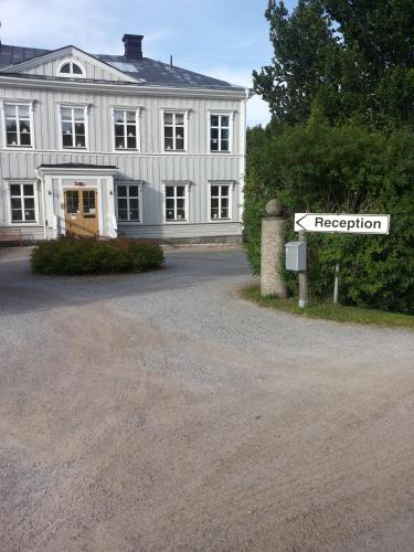 a white building with a street sign in front of it at Söråkers Herrgård in Söråker