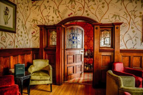 a room with a door and two chairs and a table at Fischers Baslow Hall - Chatsworth in Baslow