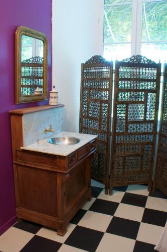 a bathroom with a wooden sink and a mirror at B&B Château de Fajac la Selve in Pech-Luna