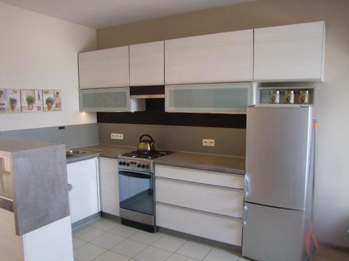 a kitchen with white cabinets and a stainless steel refrigerator at U Henriety in Wojnowice