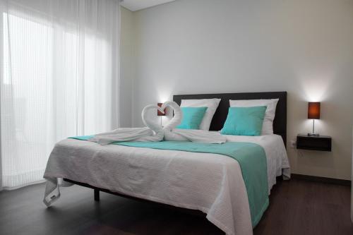 two swans sitting on a bed in a bedroom at Vale de Lourinhã - Casas de Campo in Lourinhã