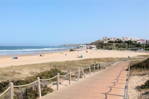 a wooden boardwalk leading to a beach with people at Vale de Lourinhã - Casas de Campo in Lourinhã
