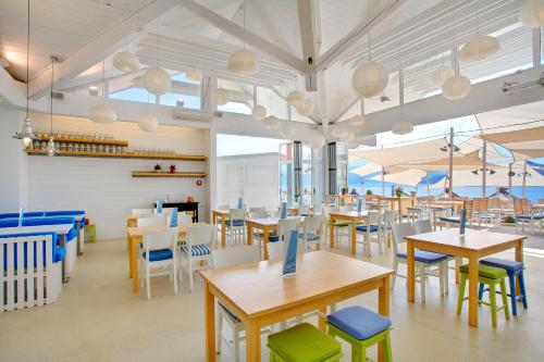 a dining room with tables and chairs and windows at Camping Bunculuka in Baška