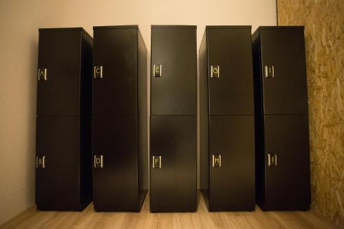 a row of black lockers in a room at Let's Hostel in Kaohsiung