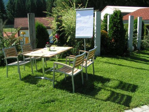 a table and chairs with a sign in the grass at Hotel Natur-Landhaus Krone in Maierhöfen