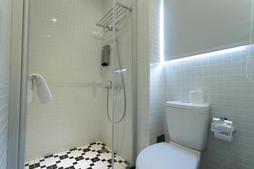 a bathroom with a shower with a toilet and a sink at Let's Hostel in Kaohsiung