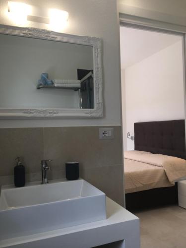 a bathroom with a sink and a mirror and a bed at B&B Somiar in San Teodoro