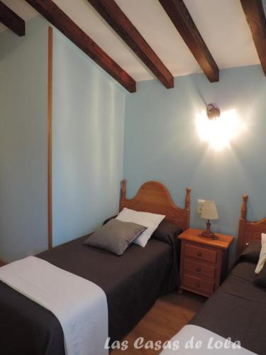 a bedroom with two beds and a table with a lamp at Las Casas de Lola in Rabago