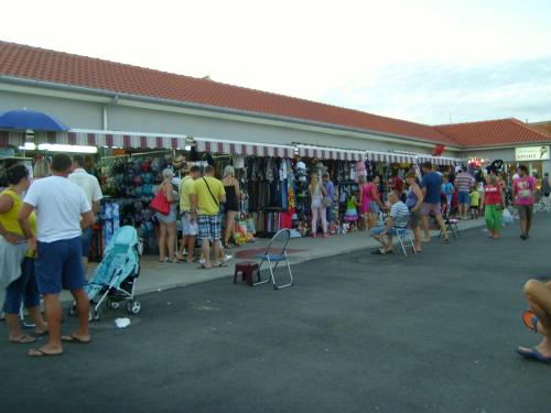 a crowd of people standing outside of a store at Apartmani Luka in Vir