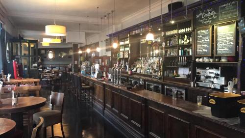 um bar num restaurante com mesas e cadeiras em The Long Room Hotel and Bar em Londres