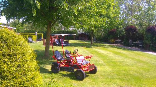 a red golf cart parked in a yard at Ferienhaus Hopp in Fehmarn