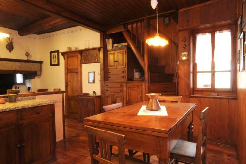 a kitchen with a wooden table in a room at Tana del Paradiso in Baceno