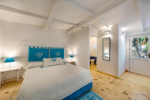 una camera da letto con un letto grande con testiera blu di Casa Saltara a Santa Teresa di Gallura