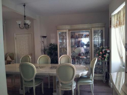 a dining room table with chairs and a china cabinet at Ruxley Rooms in Sidcup