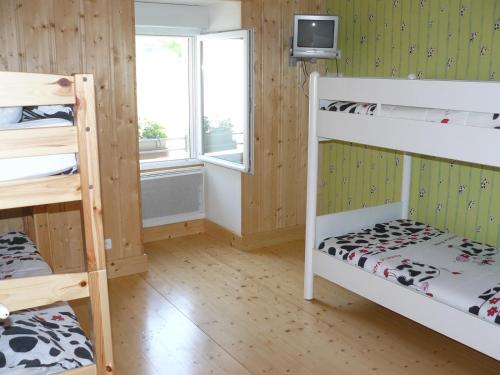 Zimmer mit 2 Etagenbetten und einem TV in der Unterkunft Gîte de la sauge in Mignovillard