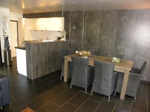 a dining room with a table and chairs and a kitchen at Bungalows Bospark te Stramproy in Stramproy