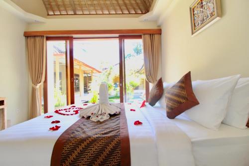 a bedroom with a white bed with a large window at With Love Bali in Gianyar
