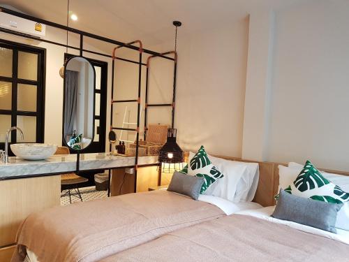 - une chambre avec un lit, une coiffeuse et un miroir dans l'établissement Treevana Club Chiangmai, à Chiang Mai