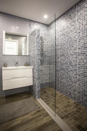 a bathroom with a glass shower with a sink and a toilet at Just Sea in Peniche