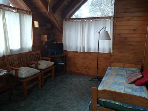 a bedroom with two beds and a lamp in a cabin at Calen-Hue in San Carlos de Bariloche