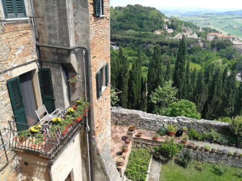 un vieux bâtiment avec des fleurs sur un balcon dans l'établissement Toscanamente, à Volterra