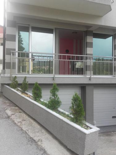a building with a balcony with trees on it at Aprtments Belma in Sarajevo